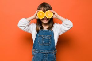 Niña sana comiendo naranja 