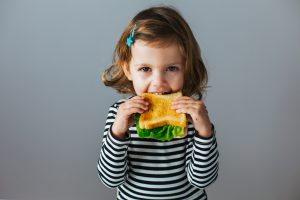 Niña sana comiendo sandwich 